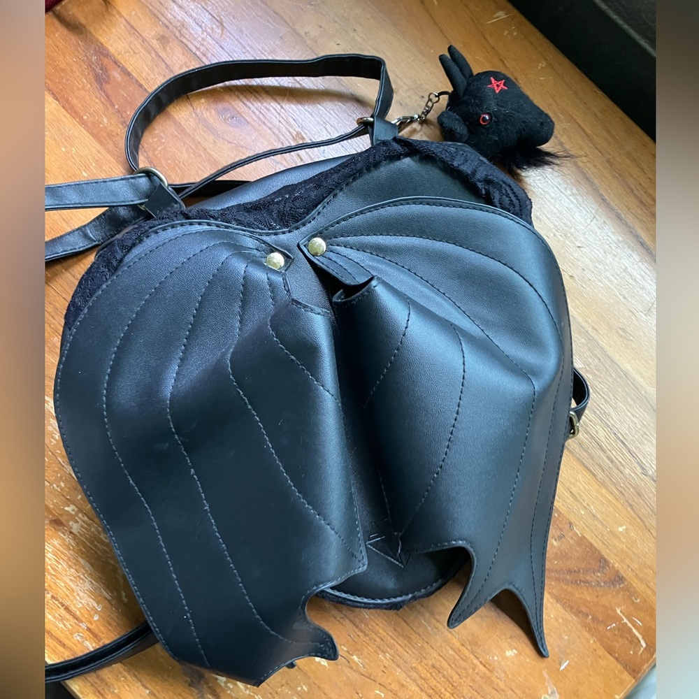 heart shaped black bag with wings, and a goat head keychain